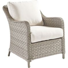 a wicker chair with white pillows on it's armrests and seat cushion