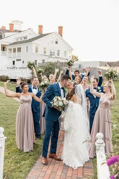 a bride and groom kissing in front of their wedding party