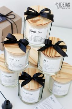 six candles with black ribbon tied around them on a white table next to a brown box