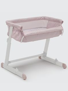 a pink and white baby crib sitting on top of a table