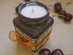 a candle that is sitting next to some plums