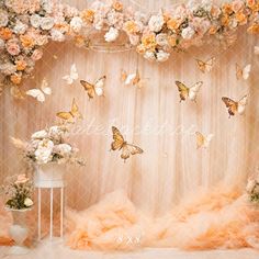 the backdrop is decorated with flowers and butterflies for an elegant wedding or special event venue