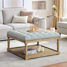 a living room filled with furniture and a coffee table on top of a rug in front of a window