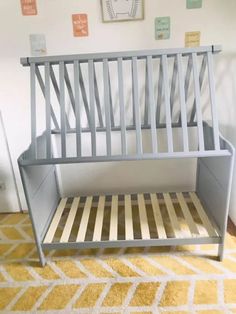 a metal bed frame sitting on top of a yellow rug in front of a white wall