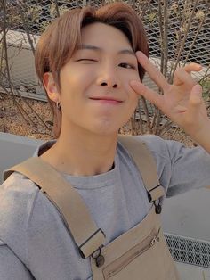 a young man making the peace sign with his fingers