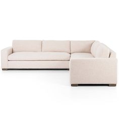 a white couch and ottoman sitting on top of a white floor next to each other