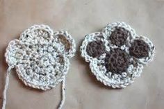 two crocheted coasters with brown and white designs on them sitting next to each other