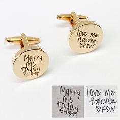 two gold cufflinks with handwriting on them