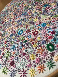 the table is covered with colorful crochet and thread work on it's surface