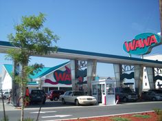 cars are parked in front of the wawa gas station