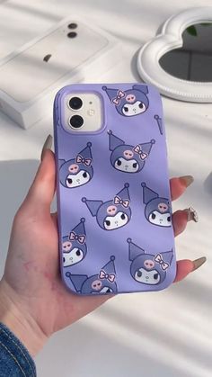 a person holding a purple phone case with cartoon characters on it