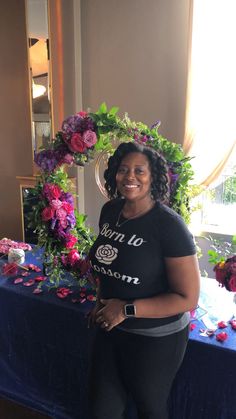 a woman standing in front of a table with flowers on it