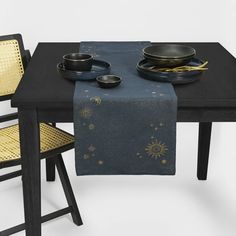 the table is set with two black plates and one yellow chair, which are also decorated with gold stars