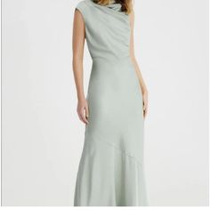 a woman is wearing a long dress with an asymmetrical neckline