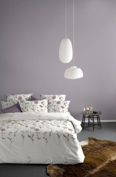 a bedroom with purple walls and white bedding