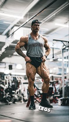 a man standing in the middle of a gym with his hands on his hips and arms behind his back