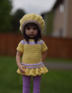 the doll is wearing a yellow knitted outfit and purple tights with matching shoes