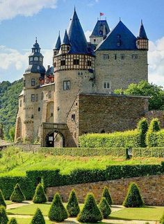 the castle is surrounded by hedges and trees