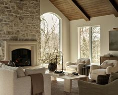 a living room filled with furniture and a fire place in front of a stone fireplace