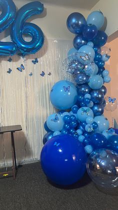 blue balloons and streamers are on display in an office setting with the number six balloon wall