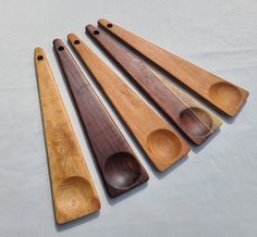 five wooden spoons are lined up next to each other