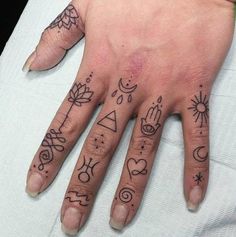 a person's hand with tattoos on it and two fingers that have different symbols