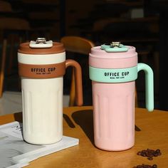 two coffee mugs sitting on top of a wooden table