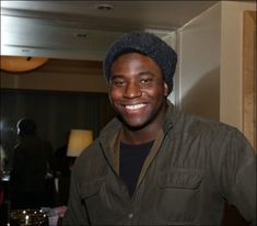 a smiling man wearing a hat in a hotel room