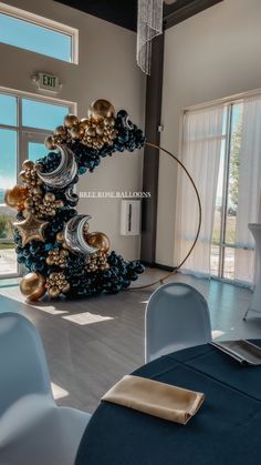 a room filled with lots of blue and gold balloons in the shape of a spiral