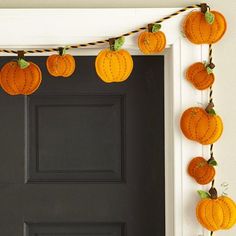 a black door with pumpkins hanging from it