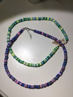 a multicolored beaded necklace on a white surface