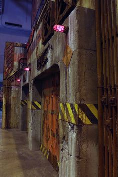 an industrial building with yellow and red stripes painted on the wall next to a fire hydrant