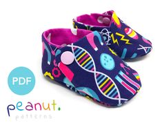 a pair of baby shoes with colorful designs on them and the words peaaut written in