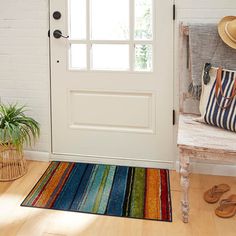 a white door with a multi colored rug next to it