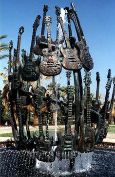 a fountain with guitars on it and water spouting from the bottom