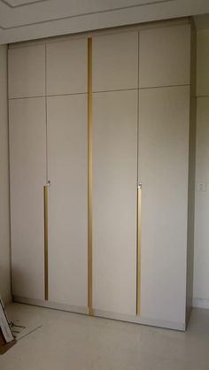 an empty room with white and gold closet doors