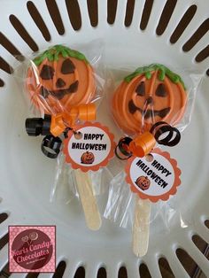 two halloween lollipops sitting on top of a white plate