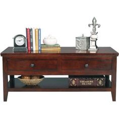 a coffee table with two drawers and books on it, next to a clock and other items