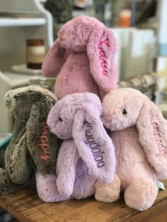 three stuffed animals sitting on top of a wooden table