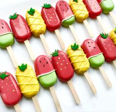 popsicles decorated with fruit are lined up on sticks