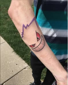 a man's arm with a cartoon character tattoo on the left side of his arm