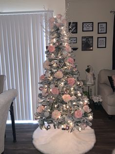 a white christmas tree decorated with pink flowers