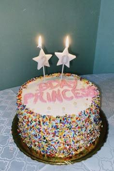 a birthday cake with sprinkles and two candles