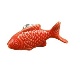 a red fish shaped keychain with a chain on it's end and a white background