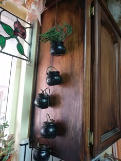 an old wooden cabinet with potted plants hanging from it