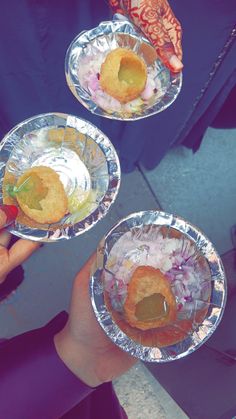 three people holding plates with food on them