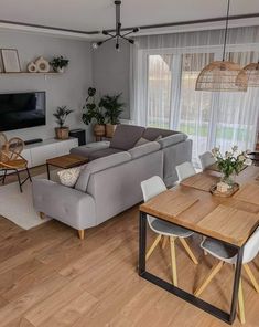 a living room filled with furniture and a flat screen tv on top of a wooden table