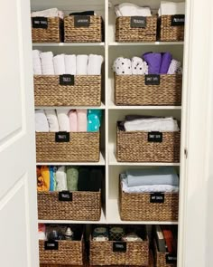 an organized closet with baskets and towels