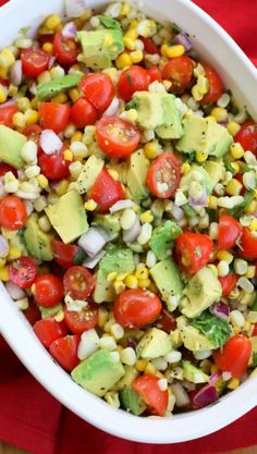 corn and avocado salad in a white bowl on top of a red napkin