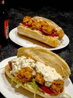 two plates with sandwiches on them sitting on a table